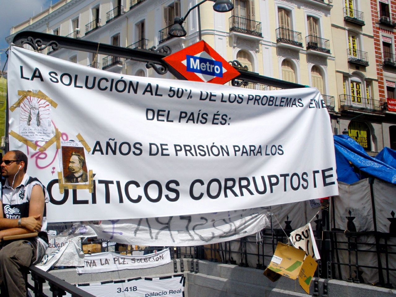 Acampada del 15M en la Puerta del Sol en mayo de 2011, con pancartas y tiendas de campaña